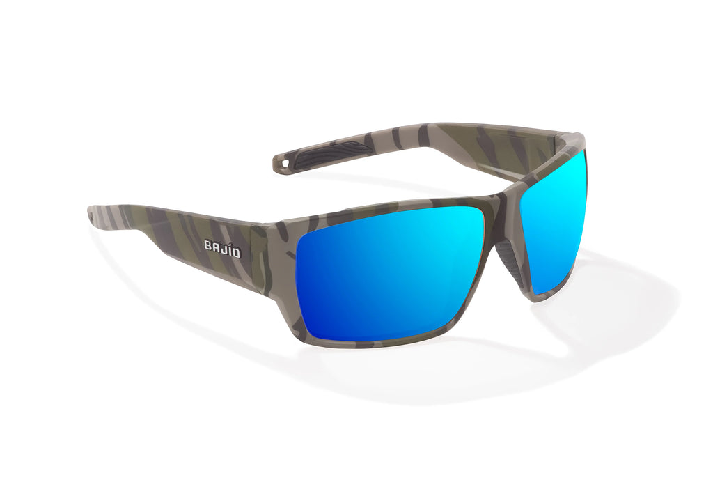 Angled view of Army Green Bottomlands Vega in collaboration with Mossy Oak x Bajio wide body sunglasses, bio-based nylon frames with blue mirror polarized lenses, full wrap, large fit, premium built in sun ledge and flex hinges, ideal for fishing and outdoor use.