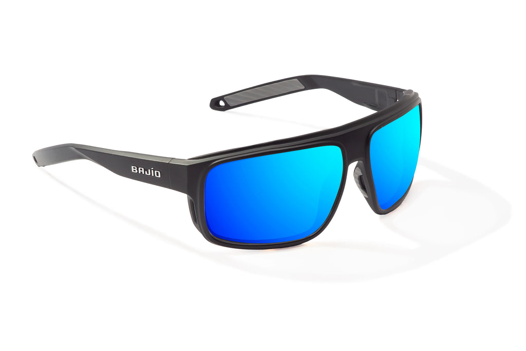 Angled view of Black Matte Greenland Bajio tech angler sunglasses, bio-based nylon frames with blue mirror polarized lenses, full wrap, large fit, premium built in sun ledge and flex hinges, ideal for fishing and outdoor use.