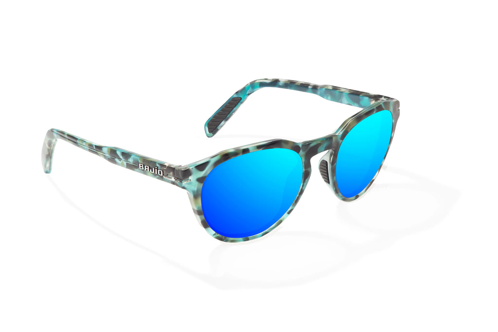 Angled view of Blue Rock Gloss Paraiso Bajio beach sunglasses, bio-based nylon frames with blue mirror polarized lenses, medium wrap, small fit premium, built in sun ledge and sturdy barrel hinges, ideal for fishing and outdoor use.