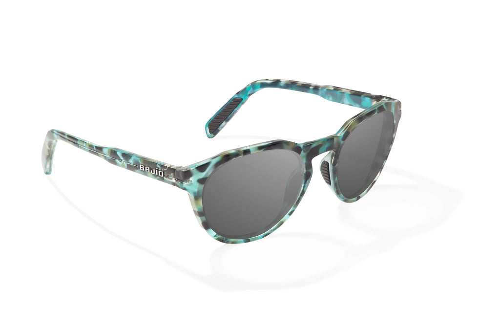 Angled view of Blue Rock Gloss Paraiso Bajio beach sunglasses, bio-based nylon frames with gray polarized lenses, medium wrap, small fit premium, built in sun ledge and sturdy barrel hinges, ideal for fishing and outdoor use.