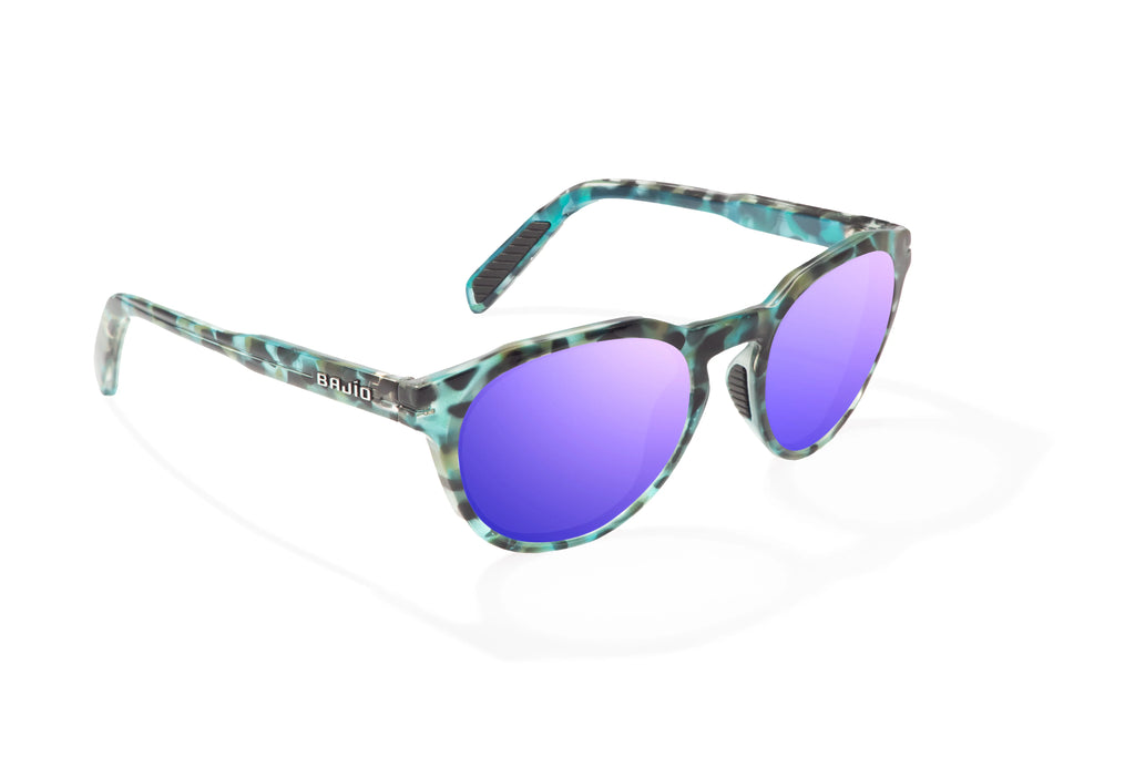 Angled view of Blue Rock Gloss Paraiso Bajio beach sunglasses, bio-based nylon frames with violet mirror polarized lenses, medium wrap, small fit premium, built in sun ledge and sturdy barrel hinges, ideal for fishing and outdoor use.